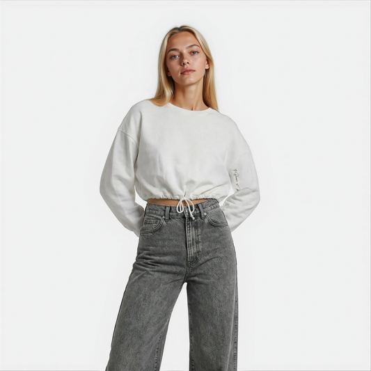 Front Close up view of a woman wearing a white cropped Malibu sweatshirt styled with grey denim — House of Malibu original design