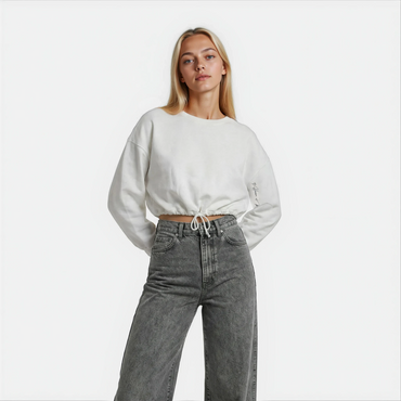 Front Close up view of a woman wearing a white cropped Malibu sweatshirt styled with grey denim — House of Malibu original design