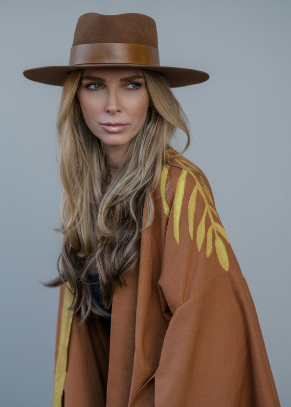 a close up view of a woman wearing a hand-painted kimono with beautiful leaves draping her shoulder.