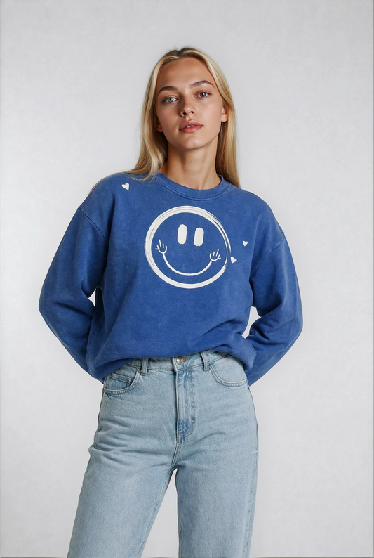 Person wearing a House of Malibu beautiful blue sweatshirt with a smiley face designed on the front with winked humor