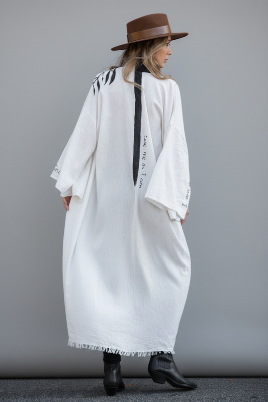 Person wearing a long light-colored kimono coat with black line down the spine alongside quote "take me as i am"