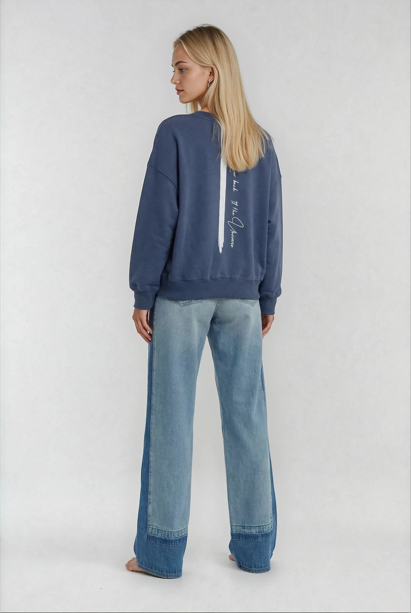 women wearing a relaxed fit cropped sweatshirt by House of Malibu in blue showcasing the signature stripe back and affirmation.