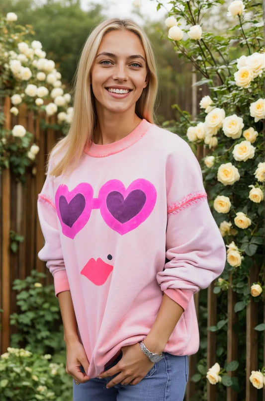 Woman wearing a House of Malibu Washed Coral Sweatshirt with Hearts and lips on the front