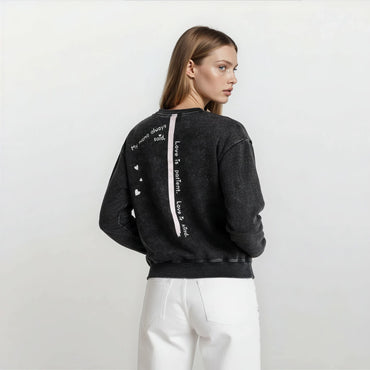 Side angle of Onyx Wash oversized boyfriend cotton sweatshirt showing spine stripe and quote and its relaxed fit.