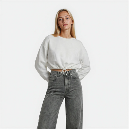 Front Close up view of a woman wearing a white cropped Malibu sweatshirt styled with grey denim — House of Malibu original design