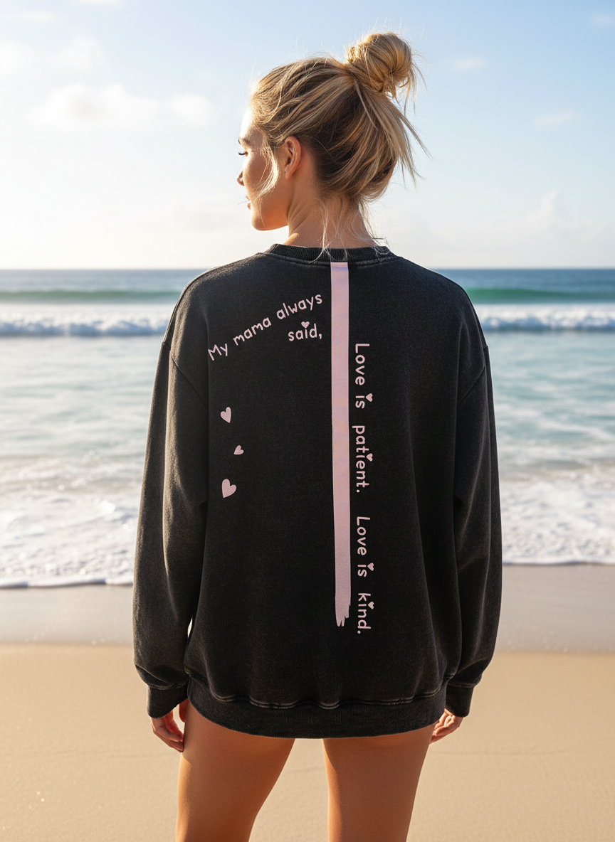 BACK VIEW OF WOMAN WEARING A BLACK SWEATSHIRT WITH QUOTE MAMA ALWAYS SAID LOVE IS PATIENT LOVE IS KIND