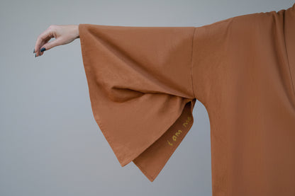close up hand-pleated sleeve with hand-painted handwritten affirmation "I am me" by House of Malibu