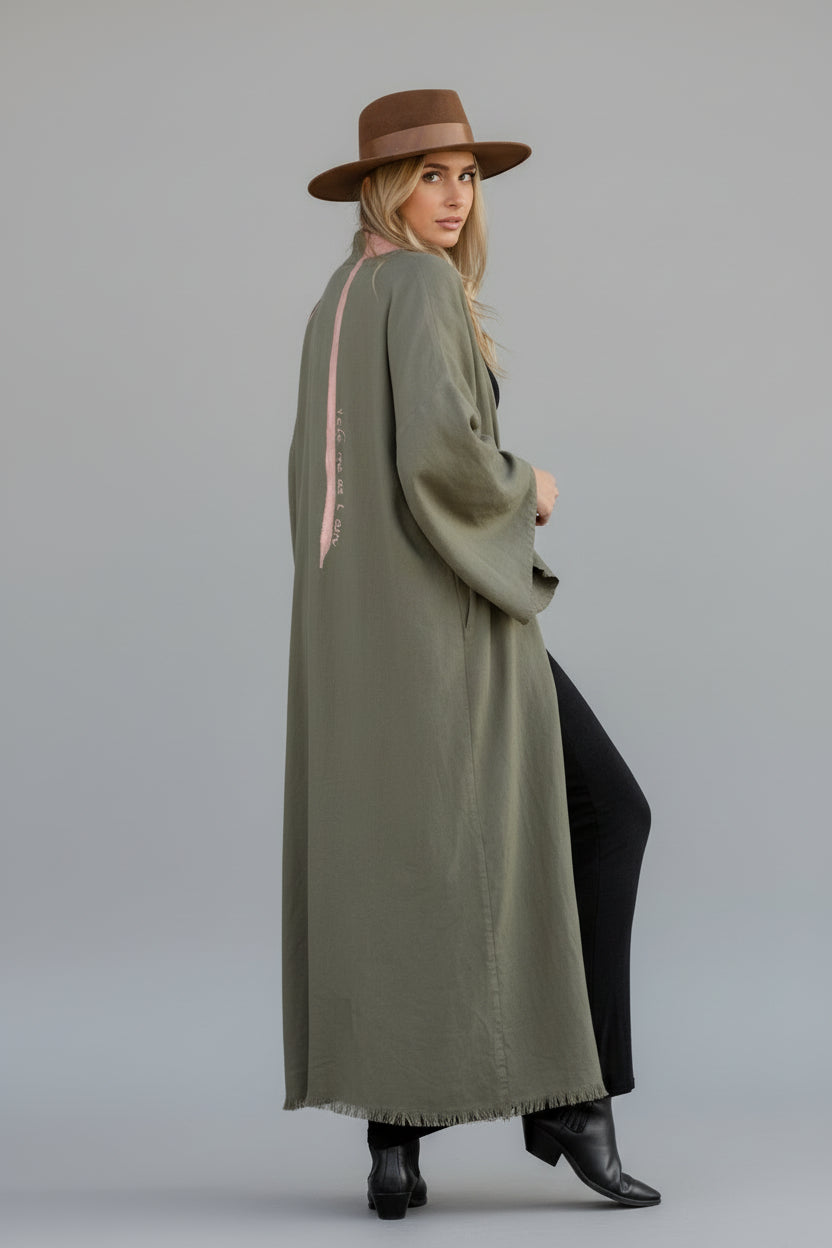 Girl wearing a long hand-painted house of malibu olive kimono with quote down the spine