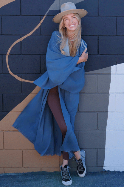 WOMAN WEARING A HAND PAINTED HOUSE OF MALIBU KIMONO IN TEAL GREY