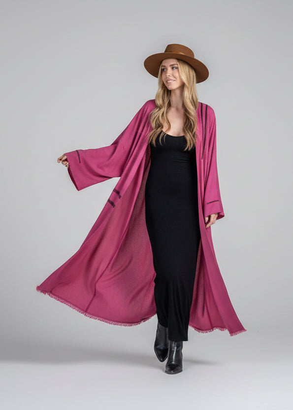 Woman wearing a  long kimono by House of Malibu styled with a hat and over a tight black dress with boots
