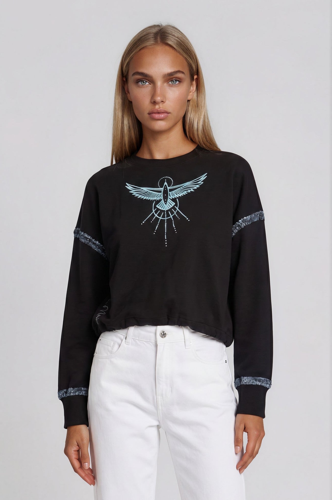 Woman wearing a black sweateshirt with a Phoenix Rises hand-painted design on the front