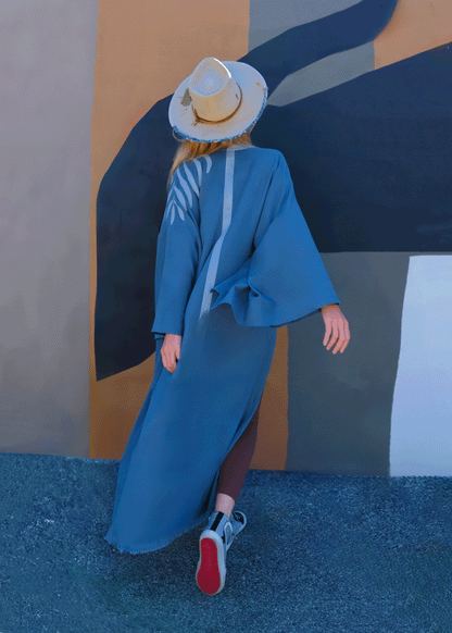 woman a house of malibu kimonowearing a teal long kimono with a painted spine stripe