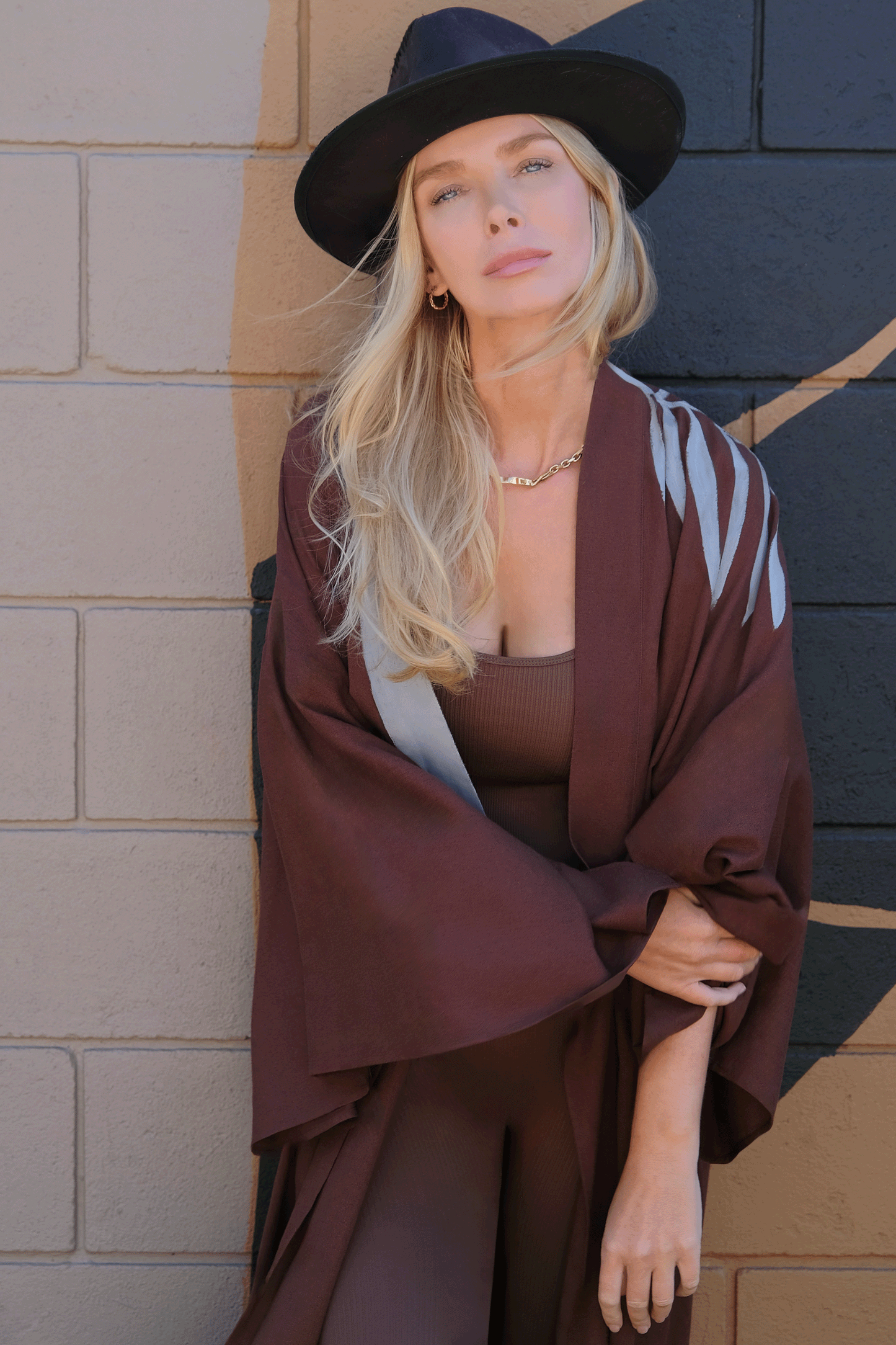 woman wearing a house of malibu brown kimono with hand-painted grey leaves draping the shoulder 