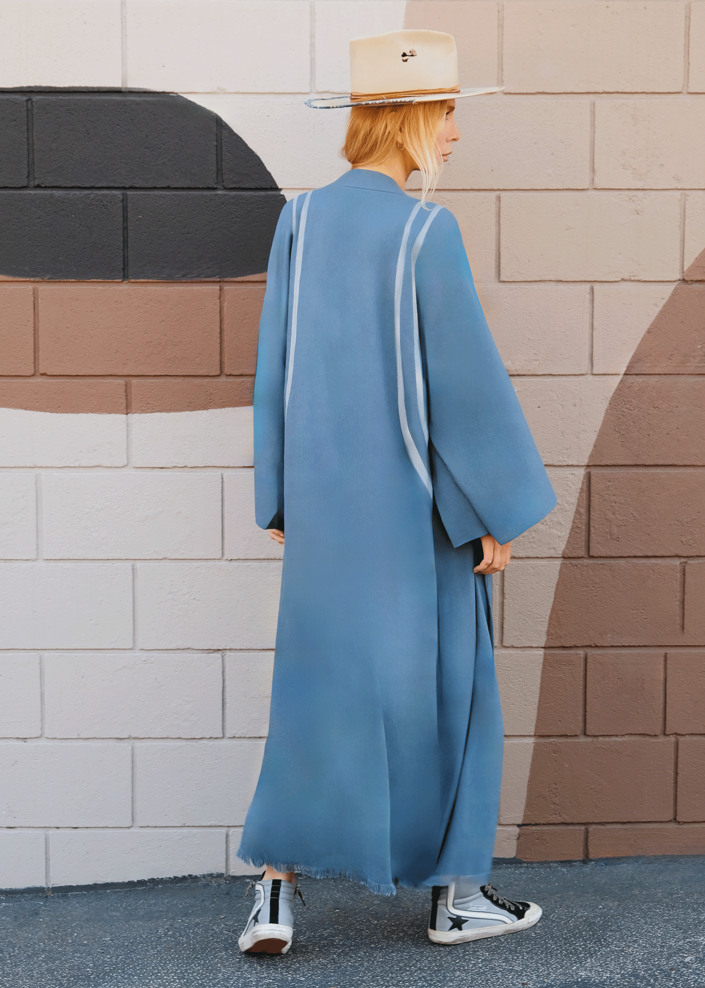 woman wearing a long flowy kimono in teal with grey stripes