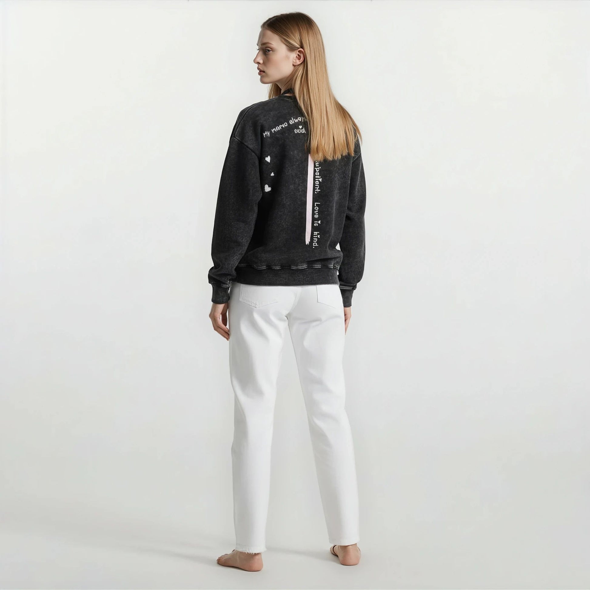 Back view of Onyx Wash sweatshirt featuring vertical quote “My mama always said, love is patient, love is kind.” worn by a woman.